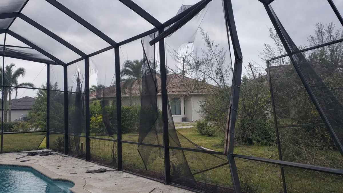 Illustrative Lee County pool screen enclosure with storm-damaged panels